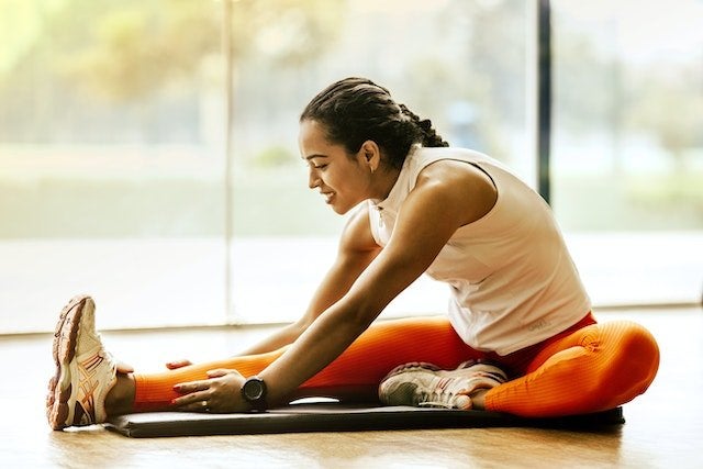 Lady in orange leggings stretching
