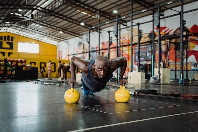 Man doing a push up on kettlebells